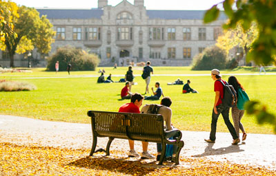 Students hanging out in the Bowl in front of the Peter MacKinnon Building